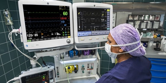 A caregivers uses GE Healthcare CARESCAPE B650 monitor to read patient's data.