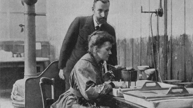 Marie Curie and assistant using old fashioned medical equipment