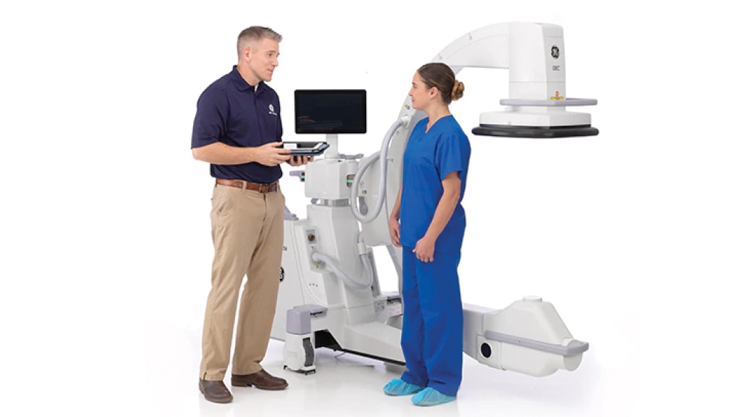 Clinician with an imaging repair technician in front of system