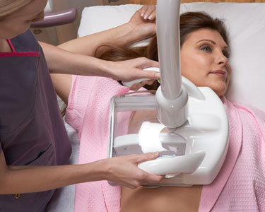 Overhead view of a woman on table getting an automated breast ultrasound exam