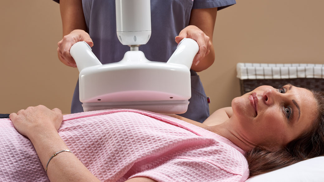 Female patient on exam table receiving an automated breast ultrasound exam