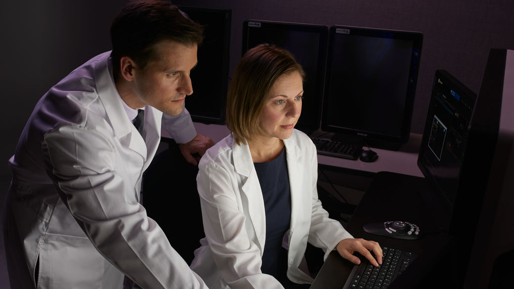 A male and female physician reviewing ultrasound images on a monitor