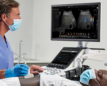 Clinician performing an abdominal ultrasound on a male patient