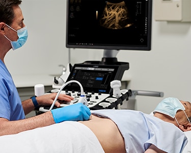 Male clinician performing an abdominal ultrasound exam