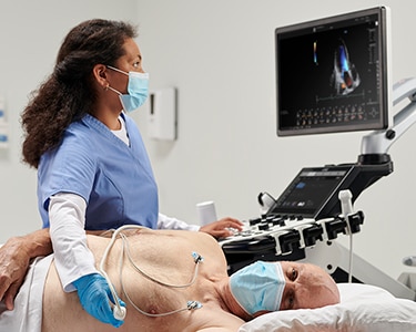 Female clinician performing a cardiac ultrasound on a male patient