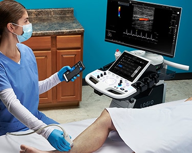 Female clinician using ultrasound to perform a vascular exam of a patient's leg