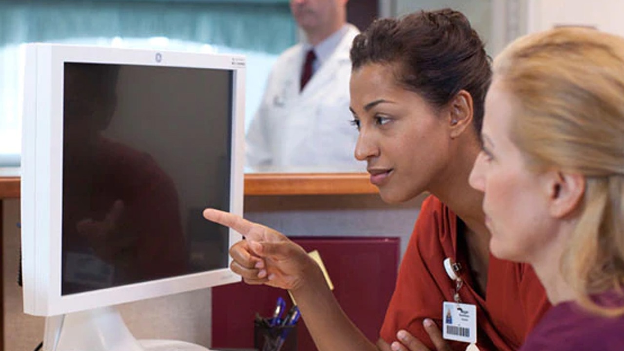 two health care providers looking at a computer monitor