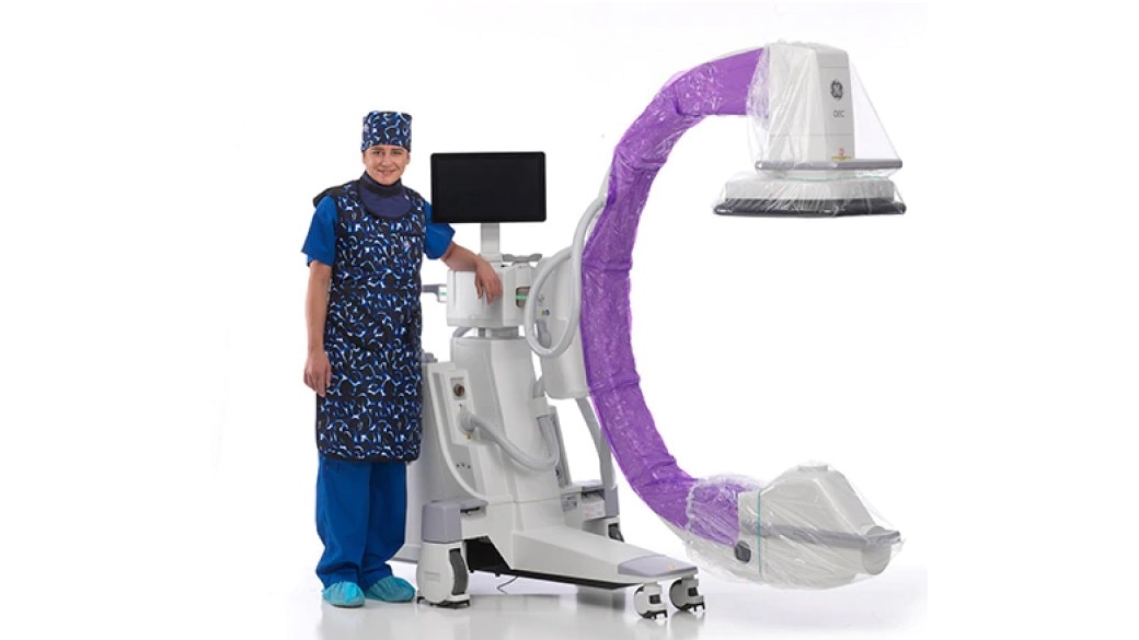 Clinician standing next to an OEC C-arm equipment 