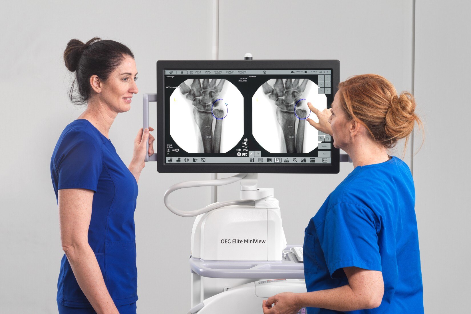 2 clinicians standing in front of the screen monitor