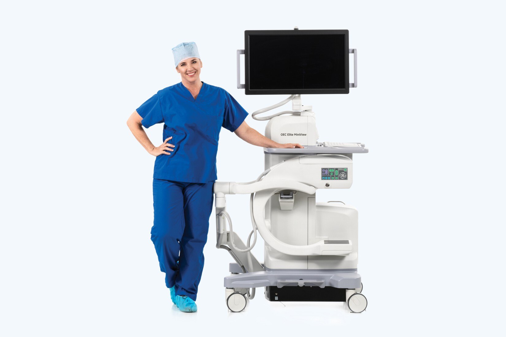 Clinician standing next to OEC Minivew machine