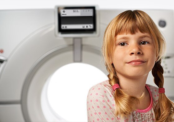 Young girl sitting on Revolution CT machine