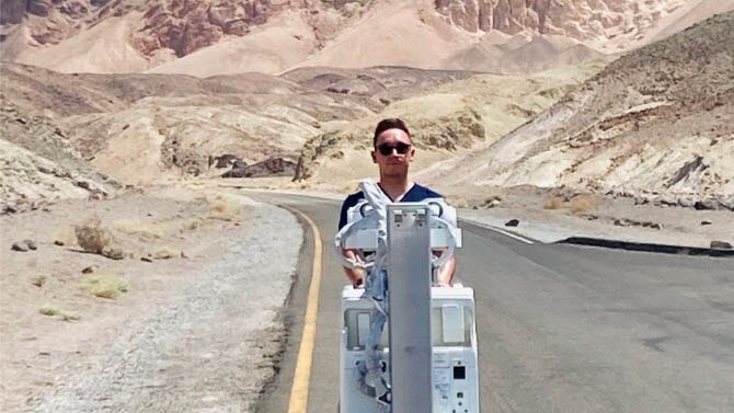 Man wheeling medical equipment through the desert
